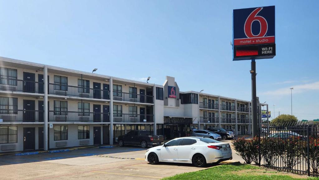 een witte auto geparkeerd voor een hotel bij Studio 6 Houston TX Medical Center NRG Stadium in Houston