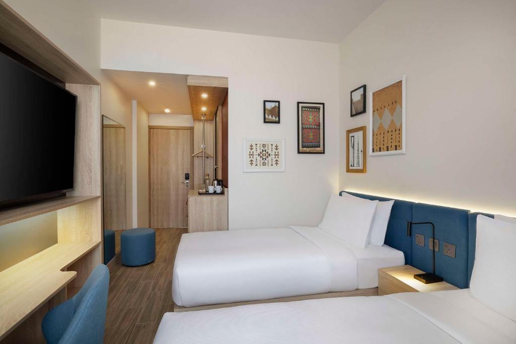Postel nebo postele na pokoji v ubytování Hampton by Hilton Sharma NEOM Community 1