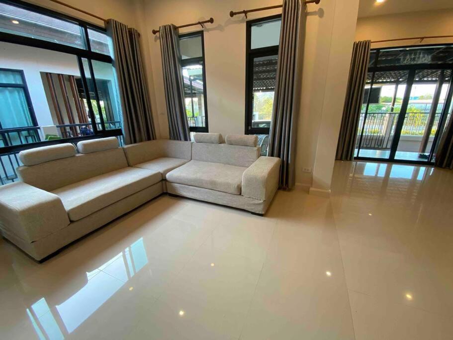 - un salon avec un canapé blanc et des fenêtres dans l'établissement Cha-am Mountain View Nature House 3 Bed 2 Bath, à Phetchaburi