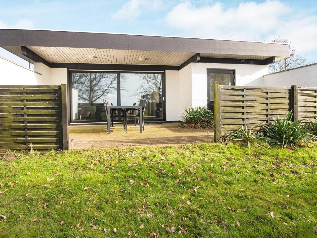 Cette maison dispose d'une terrasse avec une table. dans l'établissement Holiday home Sydals C, à Sønderby