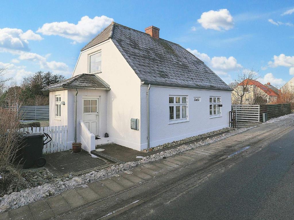 uma pequena casa branca na berma de uma estrada em Holiday home Læsø XVII em Læsø