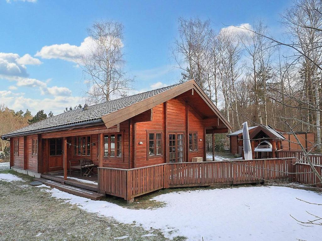 une cabane en bois avec une clôture dans la neige dans l'établissement Holiday home Læsø XII, à Læsø