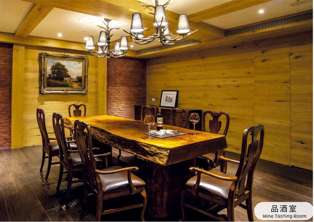 a dining room with a large wooden table and chairs at The Gaia Hotel - Taipei in Taipei