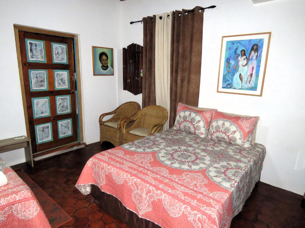 a bedroom with a bed with a red comforter at Apartment Rustic Curaçao in Willemstad