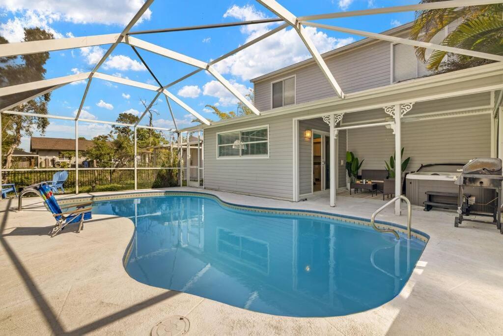 a swimming pool in front of a house at Secluded Backyard Home with Hot Tub & Pool - 3BR & 2B in Fort Myers