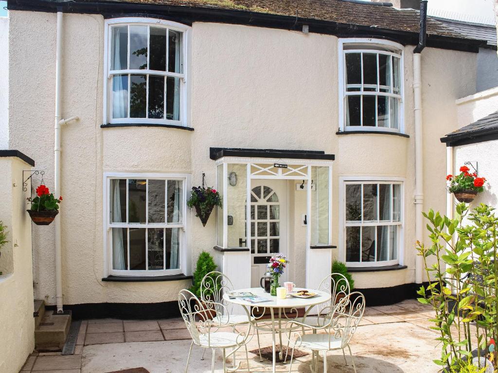 a table and chairs in front of a house at Beachside Cottage in Shaldon