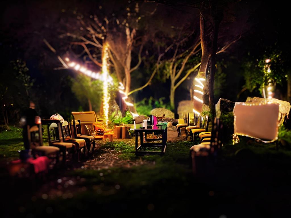 un grupo de sillas y mesas en un patio por la noche en La Poza del Pato, en Tarija