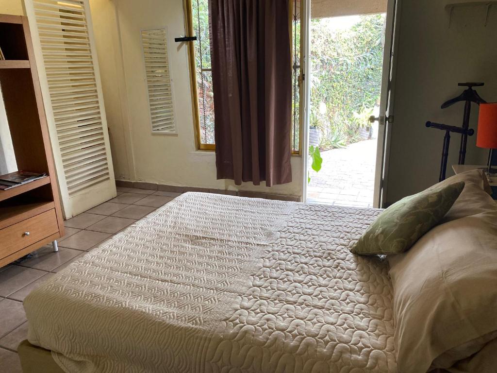 ein Schlafzimmer mit einem großen Bett und einem Fenster in der Unterkunft Quinta Ángeles in Cuernavaca