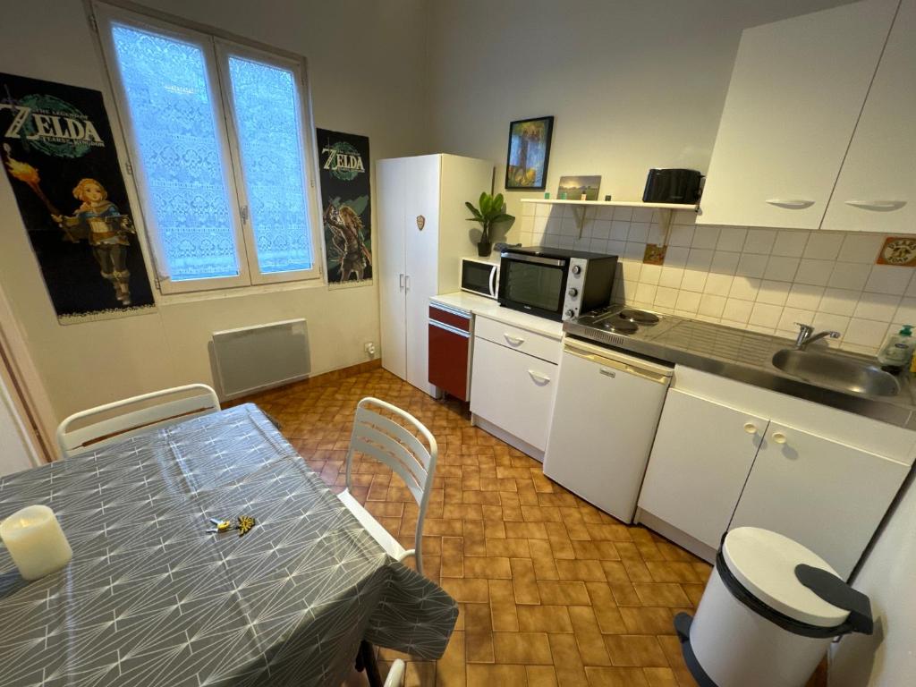 une cuisine avec une table et un comptoir dans l'établissement Zelda, à Besançon