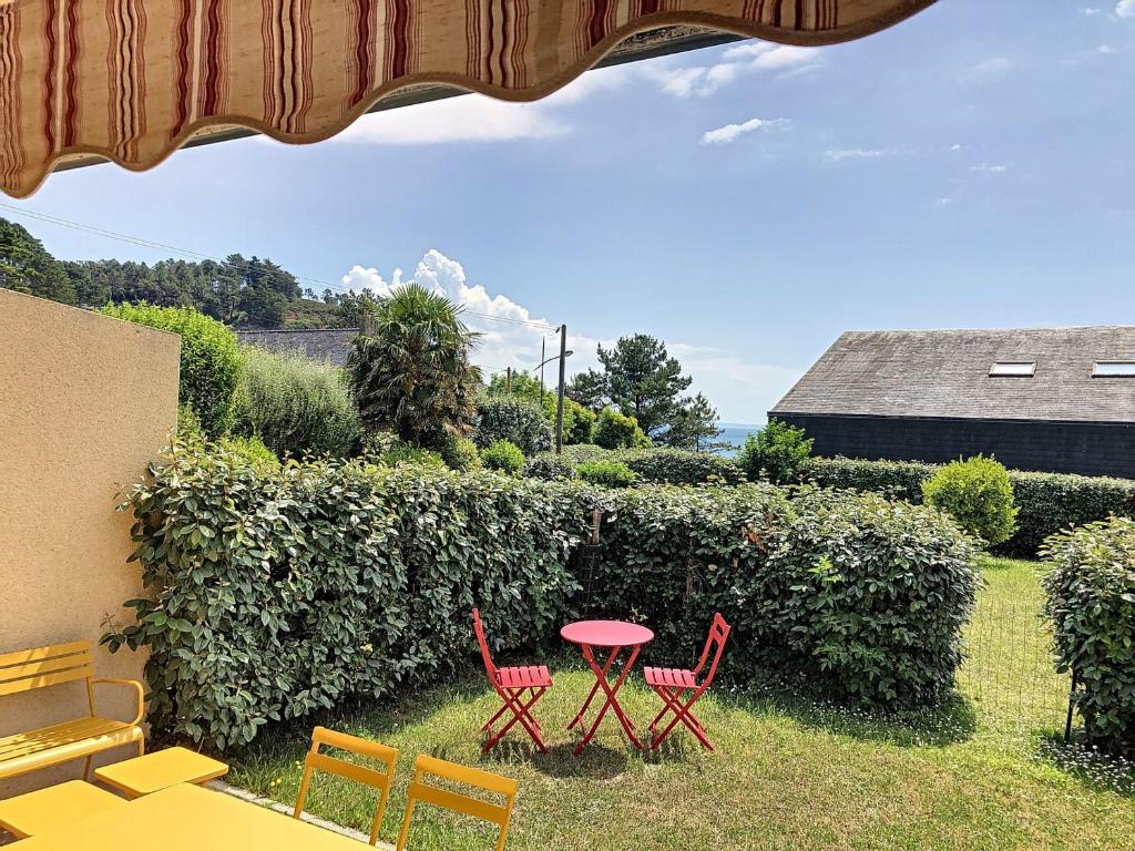 a patio with a table and chairs and a hedge at Appartement Crozon, 3 pièces, 4 personnes - FR-1-370-68 in Crozon
