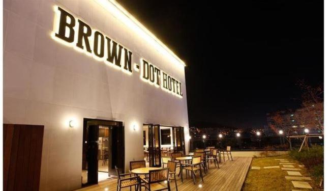 a building with tables and chairs outside at night at Brown Dot Hotel Busan Station in Busan