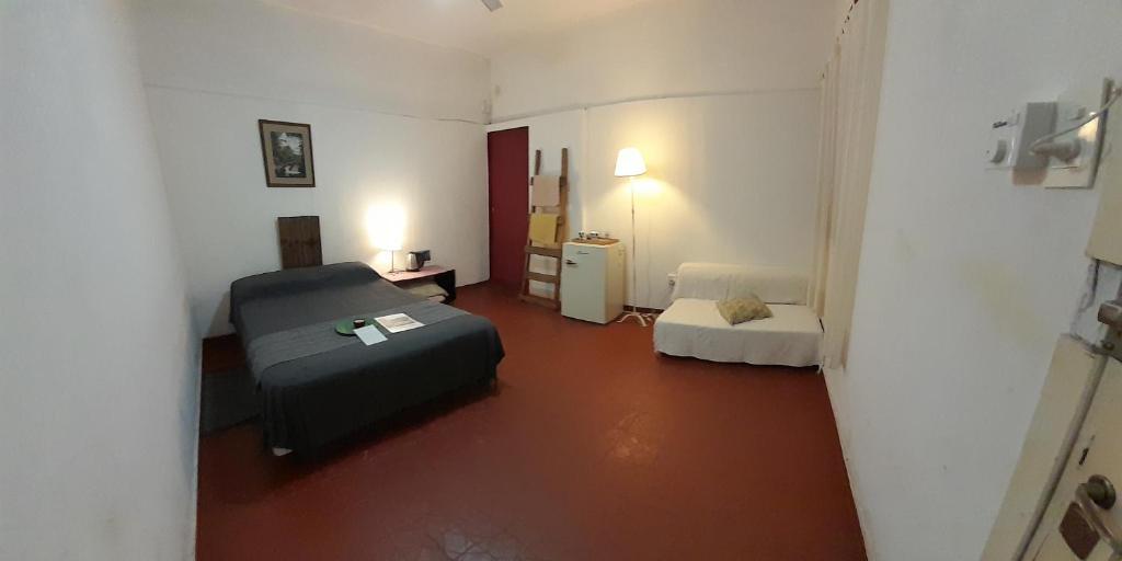 ein kleines Zimmer mit einem Bett, einem Tisch und einem Sofa in der Unterkunft Residencial Villalobos in Eldorado
