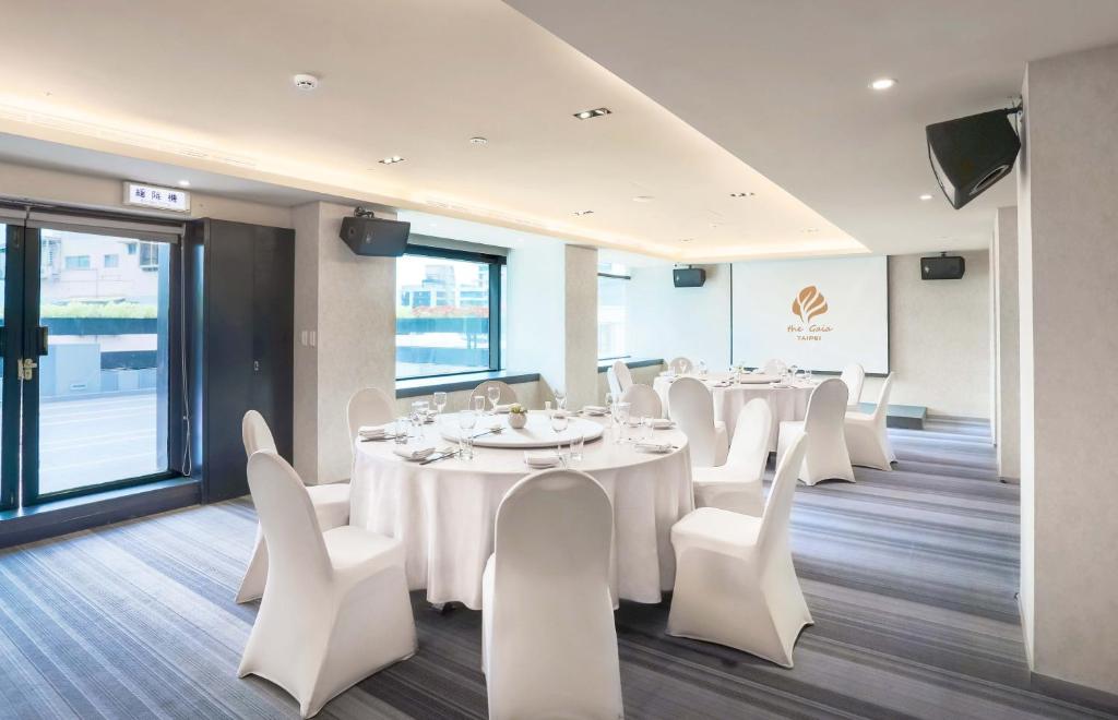 a conference room with white tables and white chairs at The Gaia Hotel - Taipei in Taipei