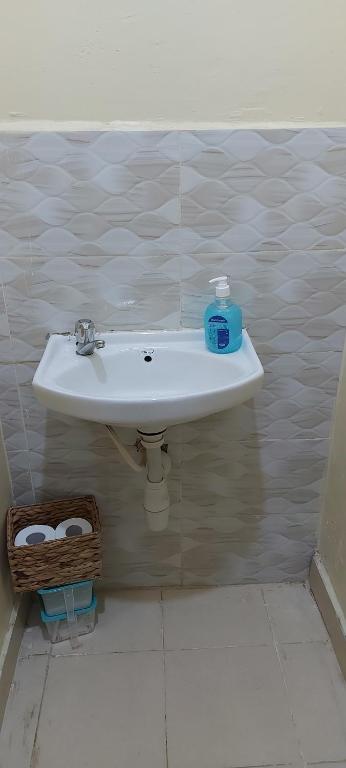 a bathroom sink with a bottle of soap on it at Airbnb in Ruiru