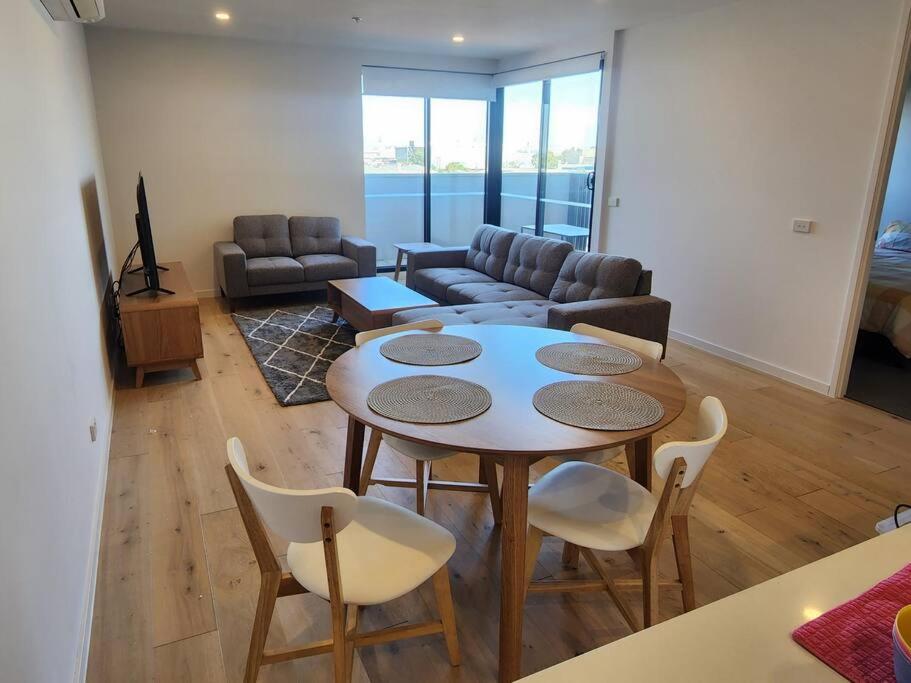 a living room with a table and chairs and a couch at Modern Apartment Airport Area in Melbourne