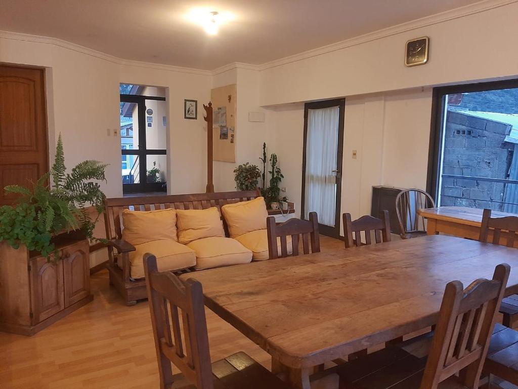 een woonkamer met een houten tafel en een bank bij TZION B&B in Ushuaia