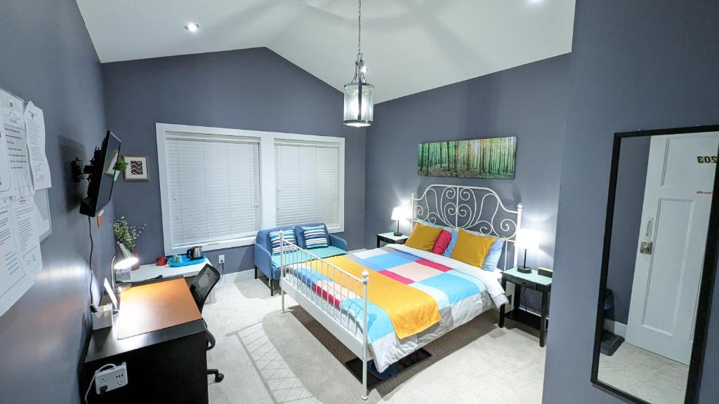 a blue bedroom with a bed and a desk at Cozy Forest Home in Surrey