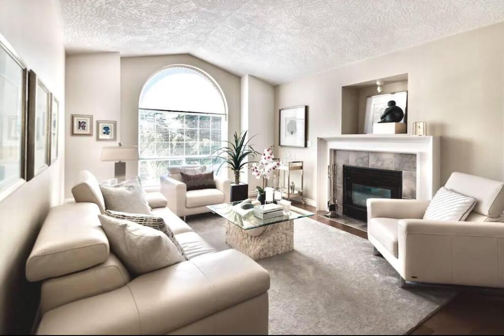 a living room with white furniture and a fireplace at Monthly Furnished Bright Beautiful 3bedroom Suite in Victoria