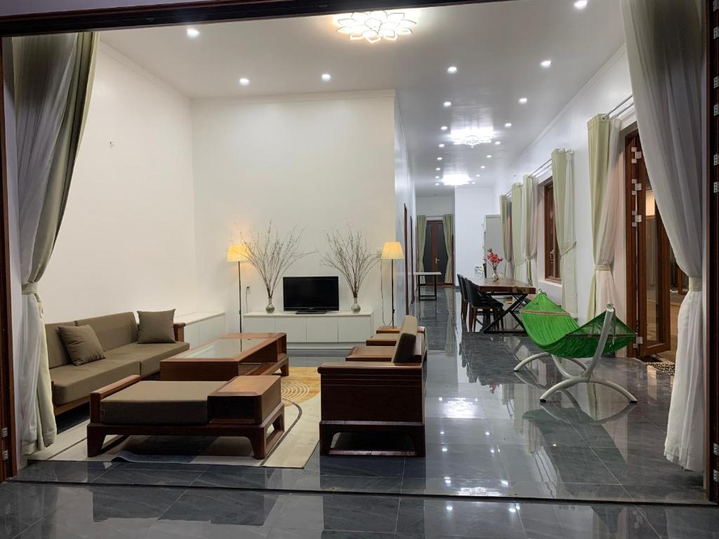 ein großes Wohnzimmer mit Sofas und einem TV in der Unterkunft Pin's House in Xã Tân Phát