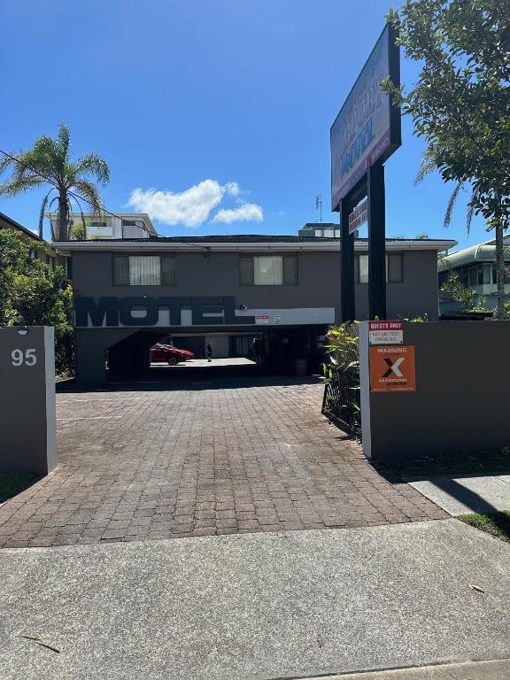 un edificio con una señal de calle delante en Gold Coast Airport Motel - Only 300 Meters To Airport Terminal, en Gold Coast