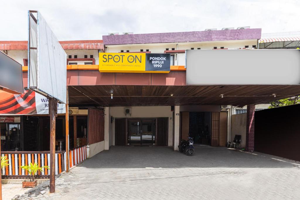 a building with a motorcycle parked in front of it at SPOT ON 1990 Pondok Ripuji in Makassar