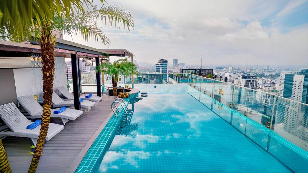 A rooftop pool and loungers overlook Danang’s dense cityscape in daylight.