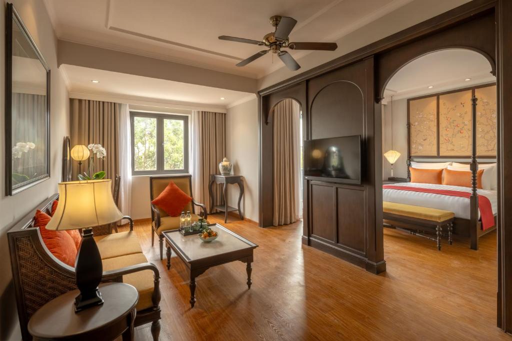 ein Schlafzimmer mit einem Bett und ein Wohnzimmer in der Unterkunft Little Residence- A Boutique Hotel & Spa in Hoi An