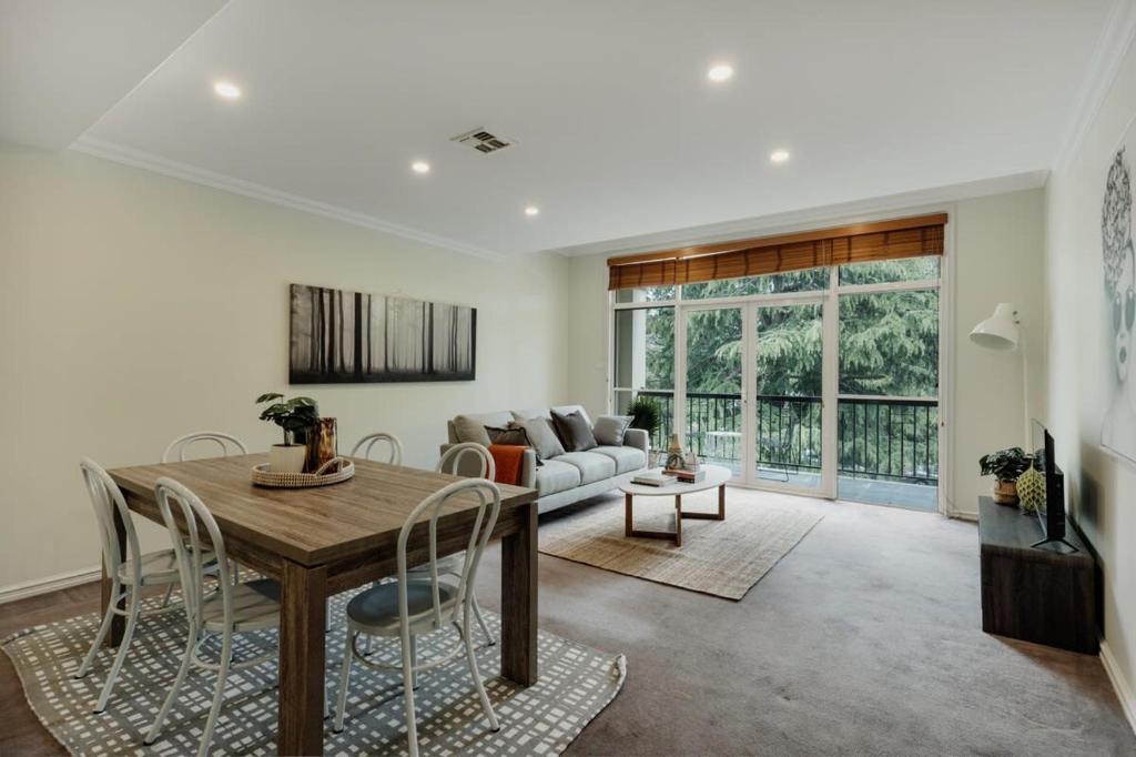 a living room with a table and a couch at Modern apartment in the heart of Canberra in Kingston 