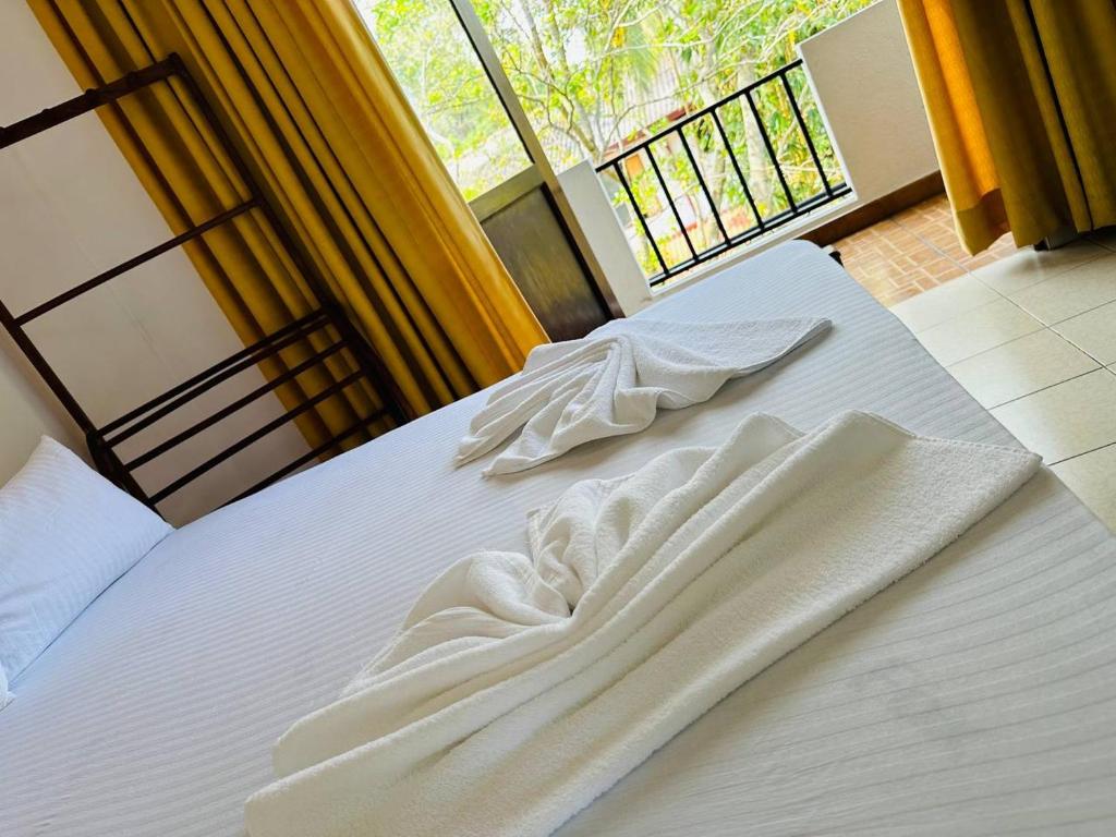 Postel nebo postele na pokoji v ubytování Blue Lotus Garden Hotel piliyandala