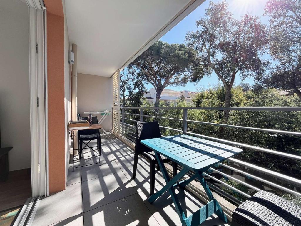 d'un balcon avec une table bleue et des chaises. dans l'établissement Confort et calme à Cavalaire : T2 climatisé avec Wi-Fi, balcon et double garage, proche centre-ville - FR-1-226B-186, à Cavalaire-sur-Mer