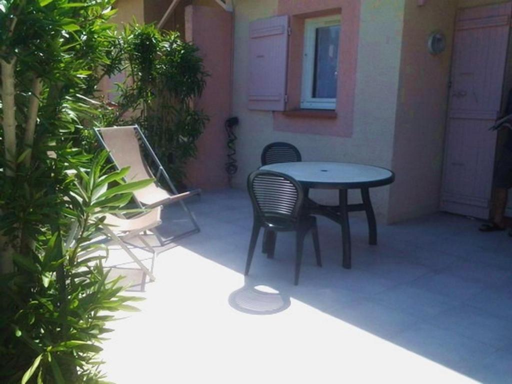 une terrasse avec une table et des chaises dans une maison dans l'établissement Villa 3 Pièces Climatisée, 5 Pers., à 800m de la Plage avec Jardin et Parking Sécurisé - FR-1-776-77, à Argelès-sur-Mer