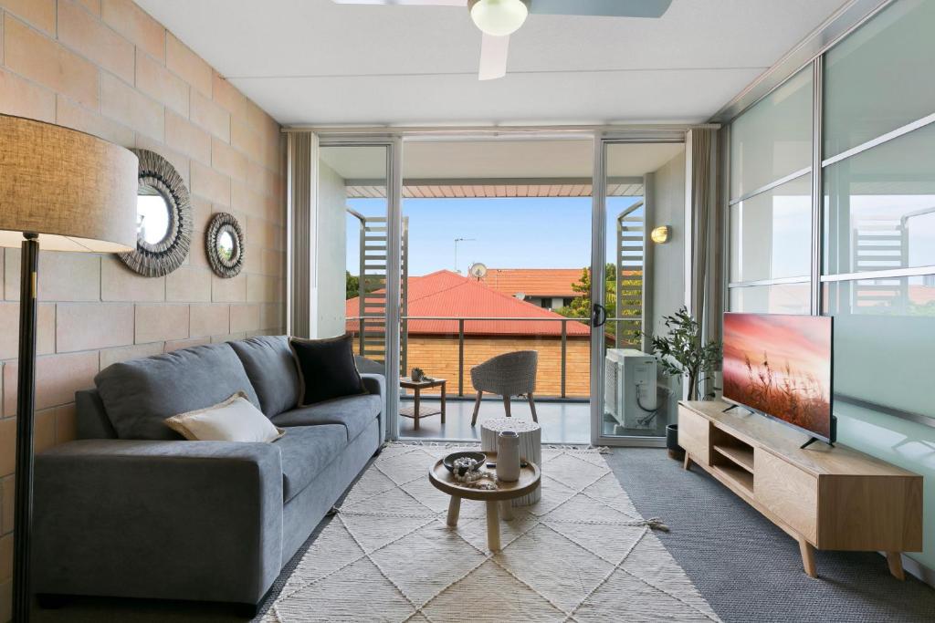 a living room with a couch and a tv at Sleek Apartment with Pool and Rooftop Terrace in Gold Coast