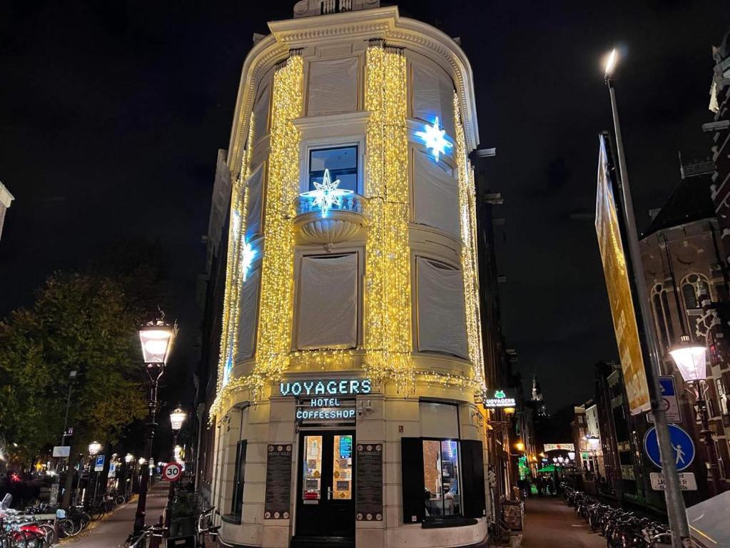 un edificio alto con luces de Navidad en él en Voyagers Amsterdam en Ámsterdam