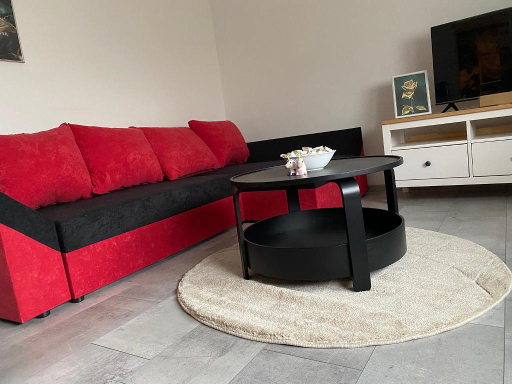 uma sala de estar com um sofá vermelho e uma mesa em 76 qm wohnen - Wohnung 1 - CSL UG em Bensdorf