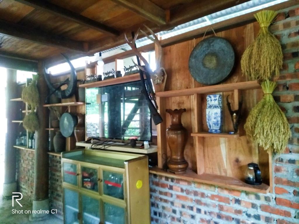 a kitchen with wooden walls and a brick wall at Hợi liên homestay in Hương Bá Thước