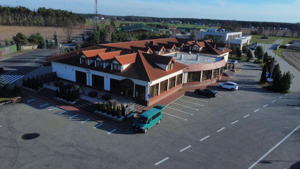 eine Luftansicht auf ein großes Gebäude mit einem Parkplatz in der Unterkunft Restauracja & Hotel Polowczyk 