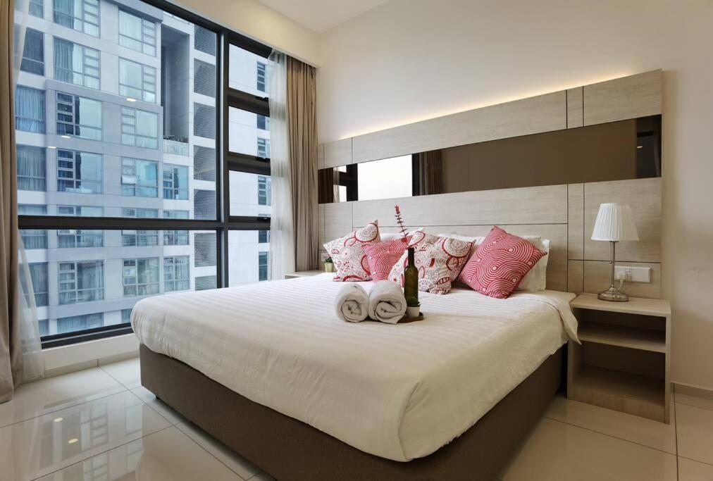 um quarto com uma cama grande e almofadas cor-de-rosa em MyCrib19*The Robertson KL - Bukit Bintang Pavilion em Kuala Lumpur