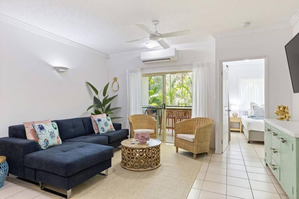 a living room with a blue couch and a table at Laidback Resort Living at Central Plaza Poolside in Port Douglas