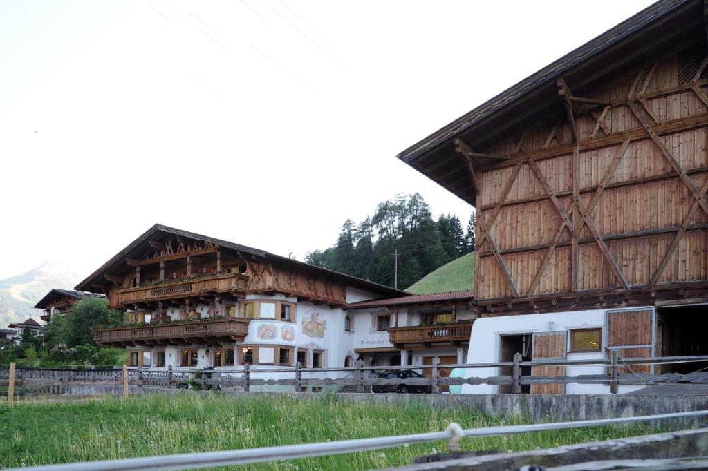 eine Gruppe von Gebäuden mit Holzdächern in der Unterkunft Pension Margretenhof in Fulpmes