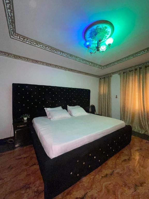 a bedroom with a large bed with a blue ceiling at Ikorodu Guest House in Lagos