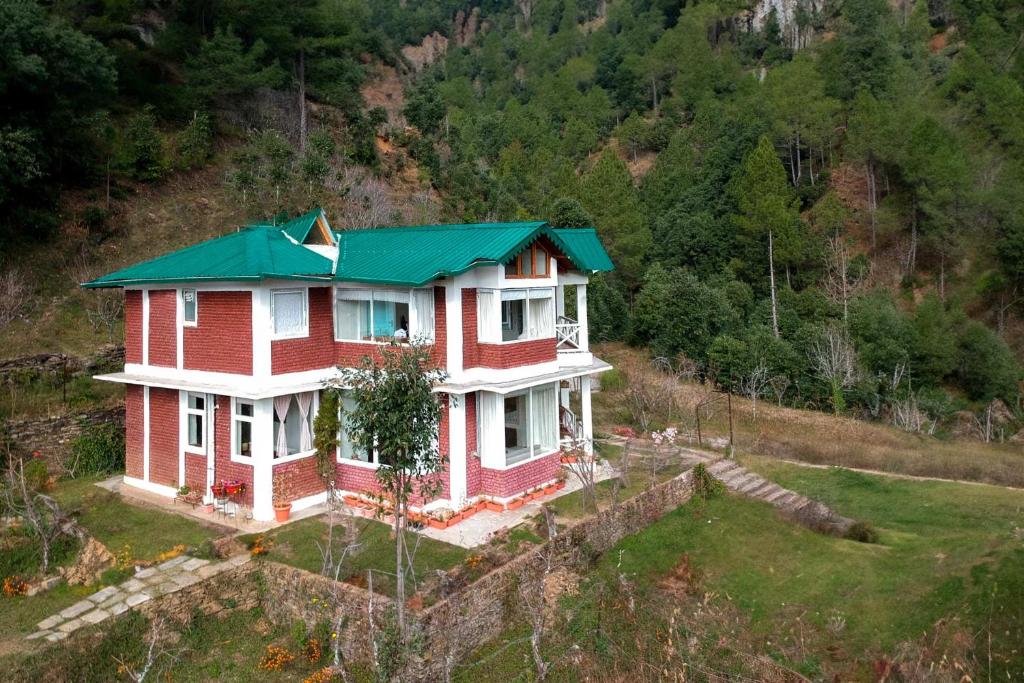 une maison avec un toit verdoyant sur une colline dans l'établissement Hollyhock Cottage by VEO - Part of StayVista, à Rāmgarh