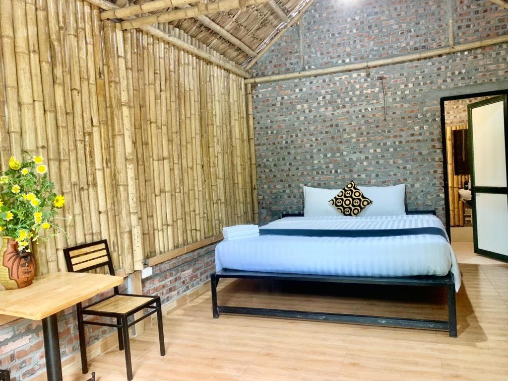 a bedroom with a bed and a table and a table and chair at Cat Ba Island Garden Homestay - Papillon in Cat Ba