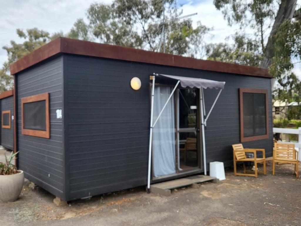 a black tiny house with a pitched roof at C and C Backpack in Stawell