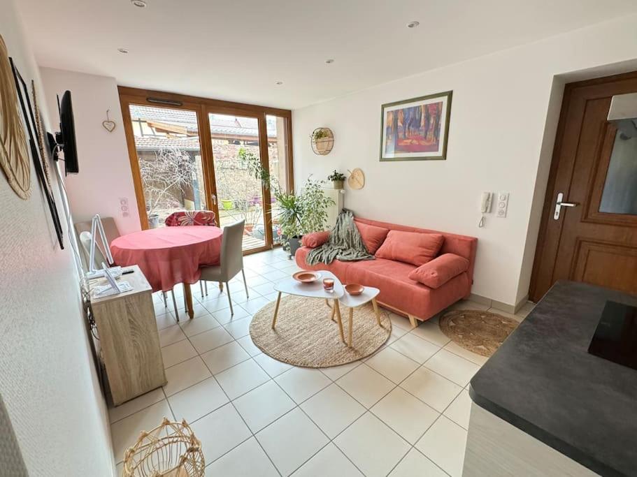 ein Wohnzimmer mit einem roten Sofa und einem Tisch in der Unterkunft Escapade campagnarde dans ancien corps de ferme in Molsheim