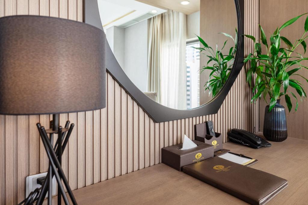 A built-in writing desk with a telephone, mirror and hotel stationery.