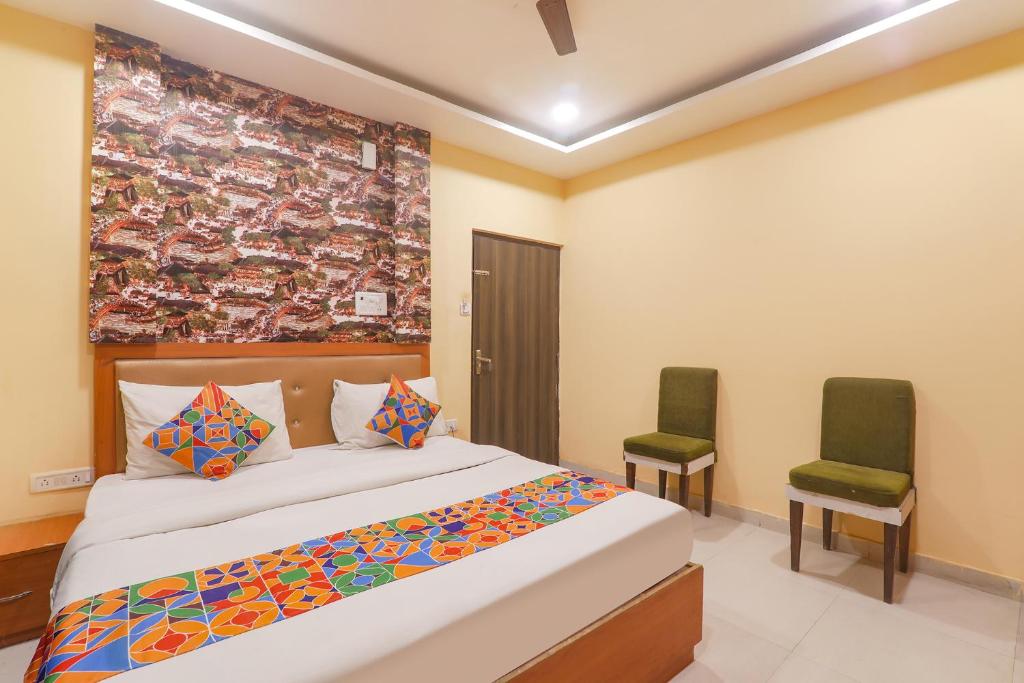 1 dormitorio con 1 cama y 2 sillas en FabHotel Swarn Banquet en Kakarmatha