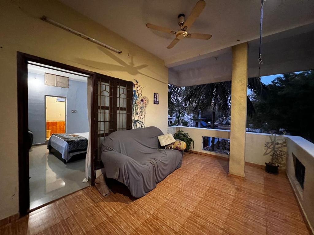 a living room with a couch and a ceiling fan at MOA Auroville pondicherry in Auroville