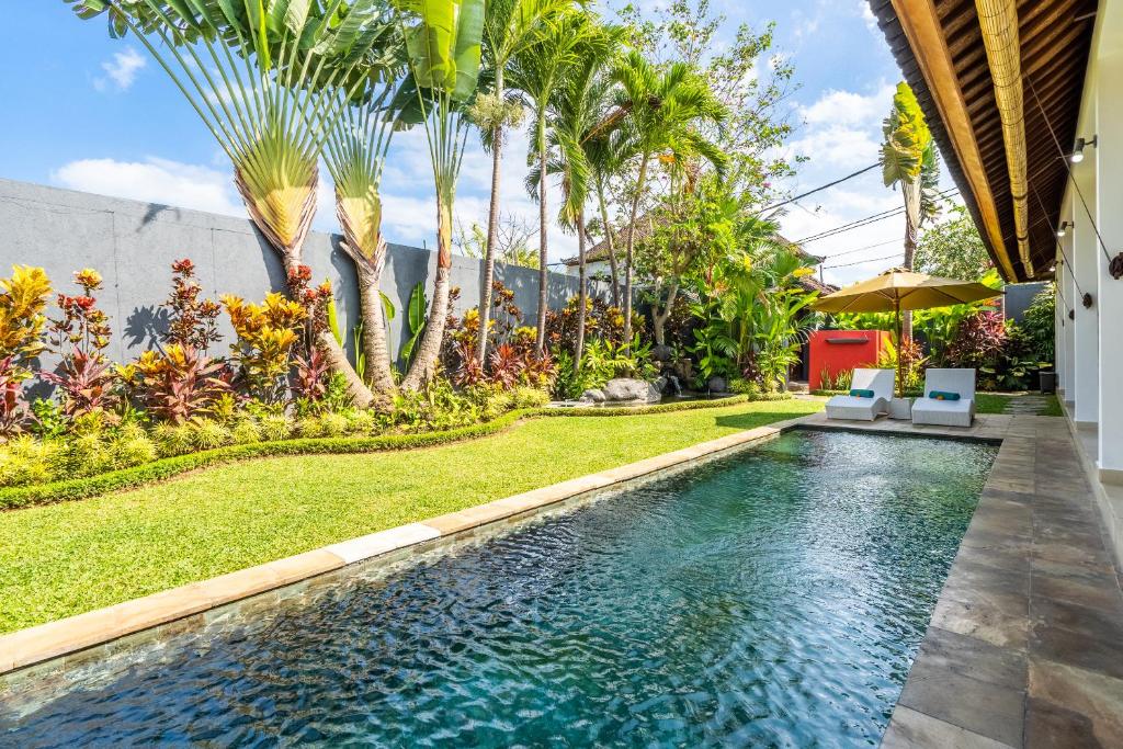 uma piscina num quintal com palmeiras em Romantica Villa Ubud em Ubud