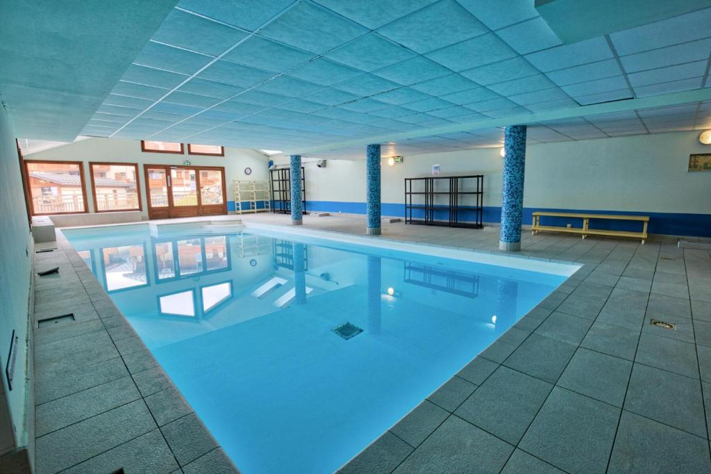ein großer Pool in einem Gebäude in der Unterkunft Les Chalets Des Evettes - 2 Pièces pour 4 Personnes 94 in Notre-Dame-de-Bellecombe