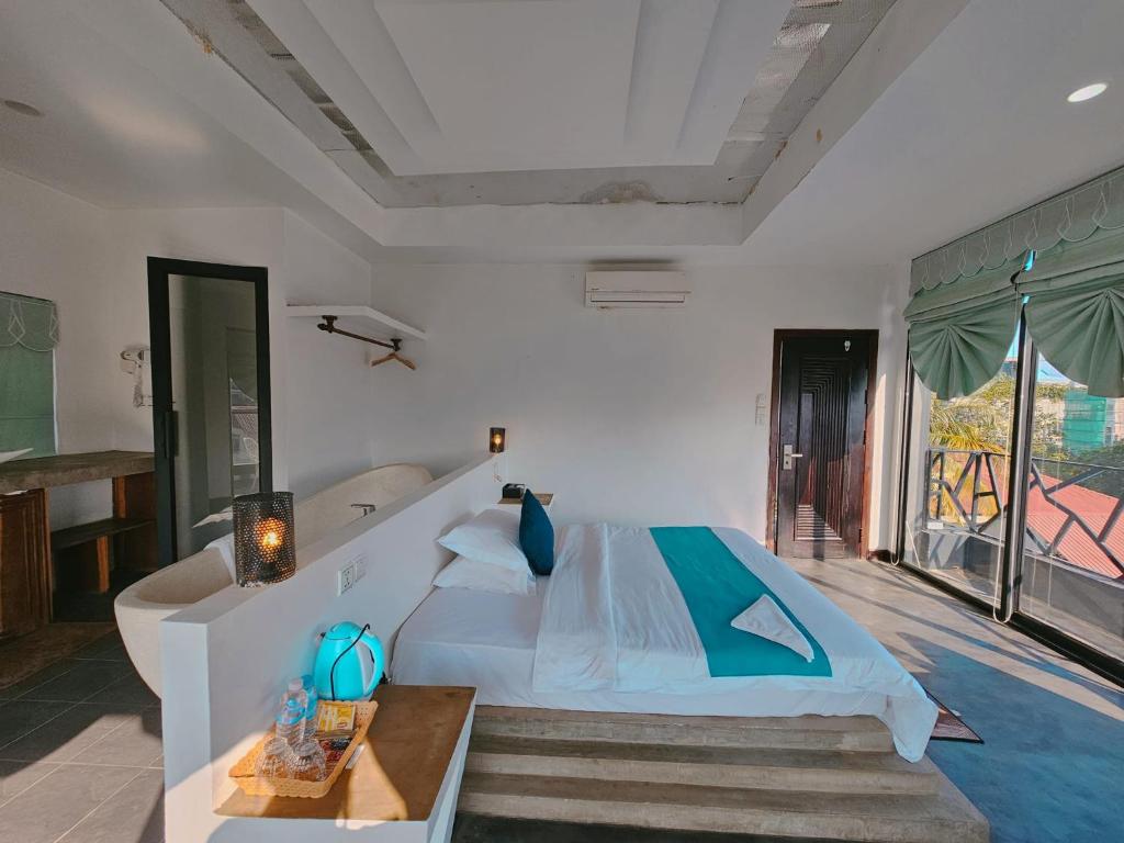 a bedroom with a large bed and a balcony at Angkor Sand Hotel in Siem Reap
